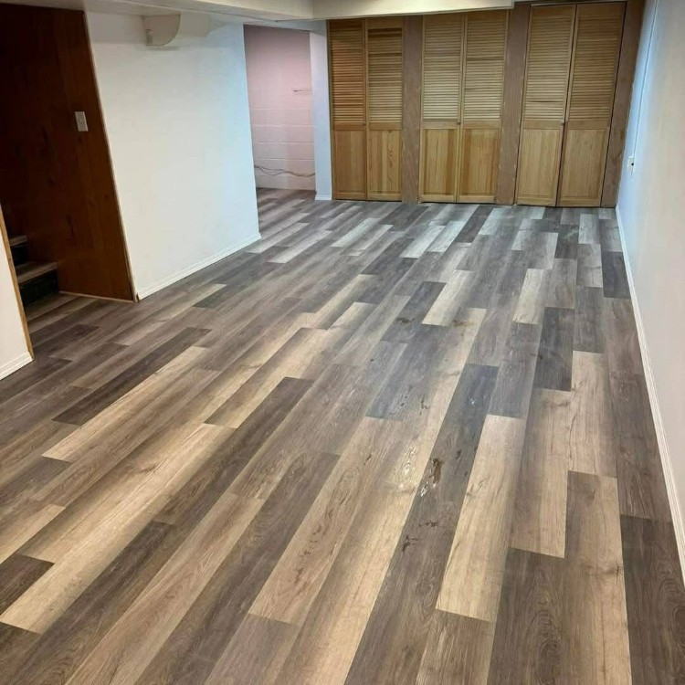 Luxury vinyl flooring installation showcasing a modern, wood-like design with varying shades, enhancing interior aesthetics in a residential space.
