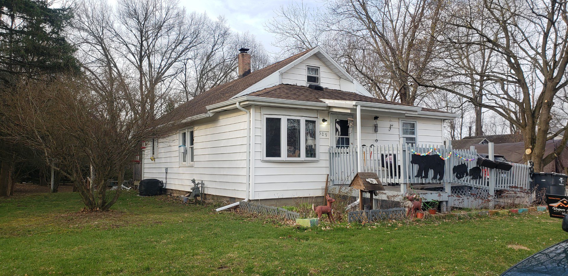 Exterior of a residential home in Northern Indiana with white siding, a gray porch railing, and decorative elements, showcasing the potential for professional painting services by Forge Construction & Design.